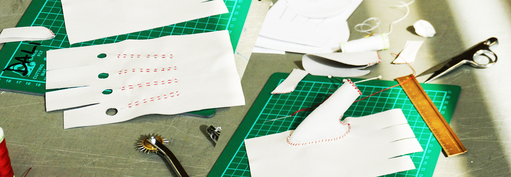 White leather gloves on a desk, being work one, surrounded by material and equipment.