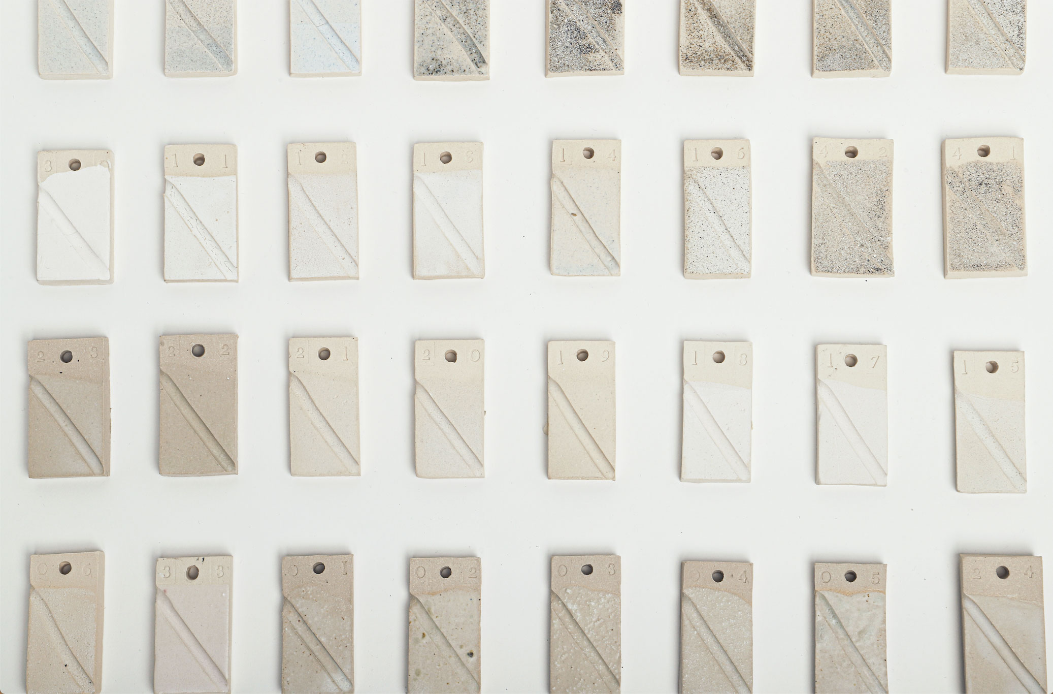 Series of rectangular glaze texts in shades of grey and white