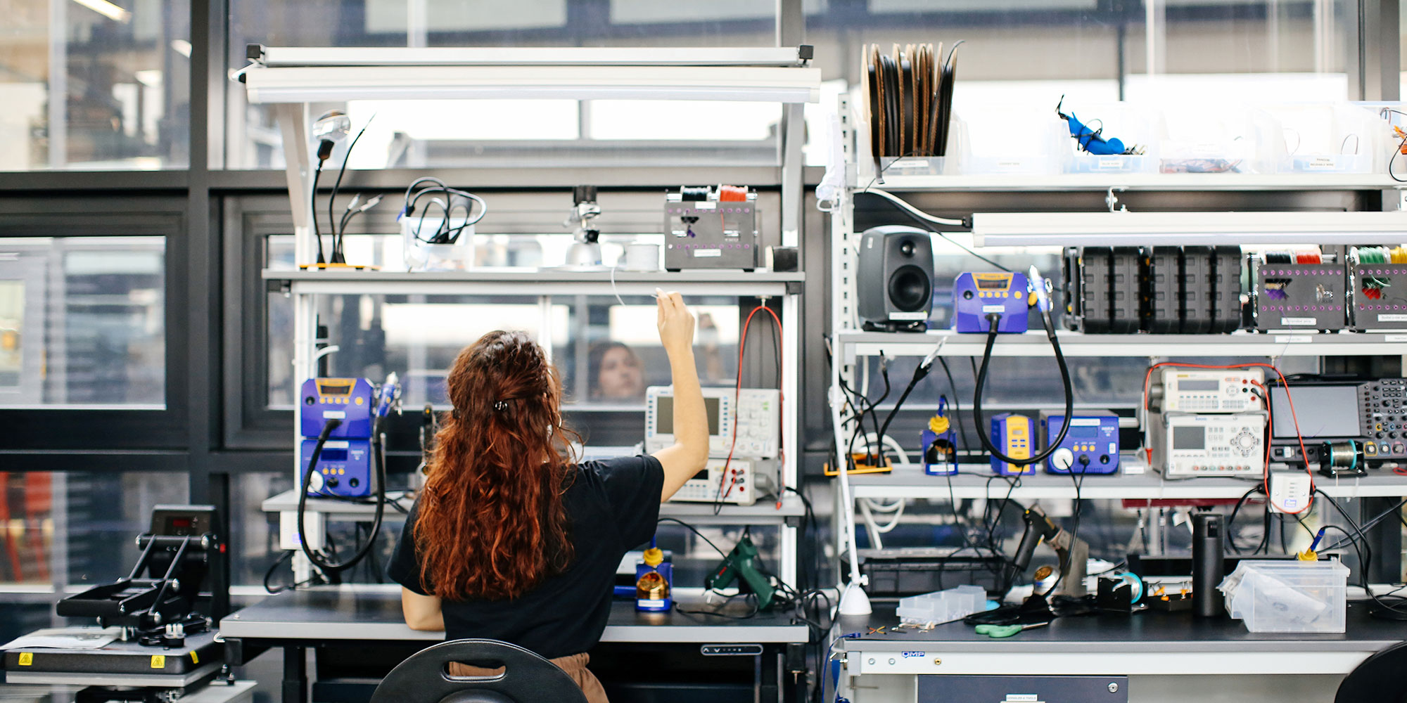 Student working in the Physical Computing Lab surrounded by lots of computational equipment