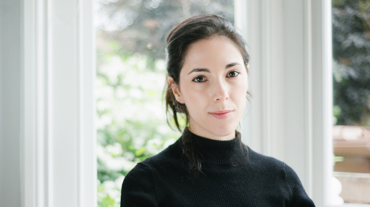 Portrait of Chiara, who has fair skin and black hair, wearing a black turtleneck