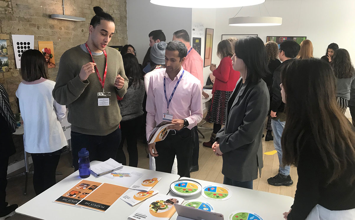 A group of students and audience members peer at project assets.