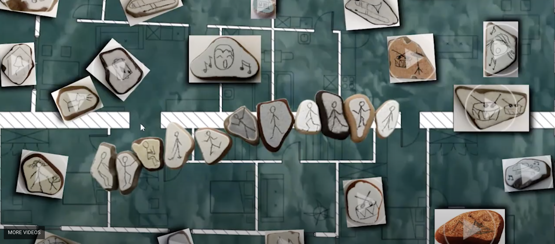 Still from video of various pebbles laid over a green board