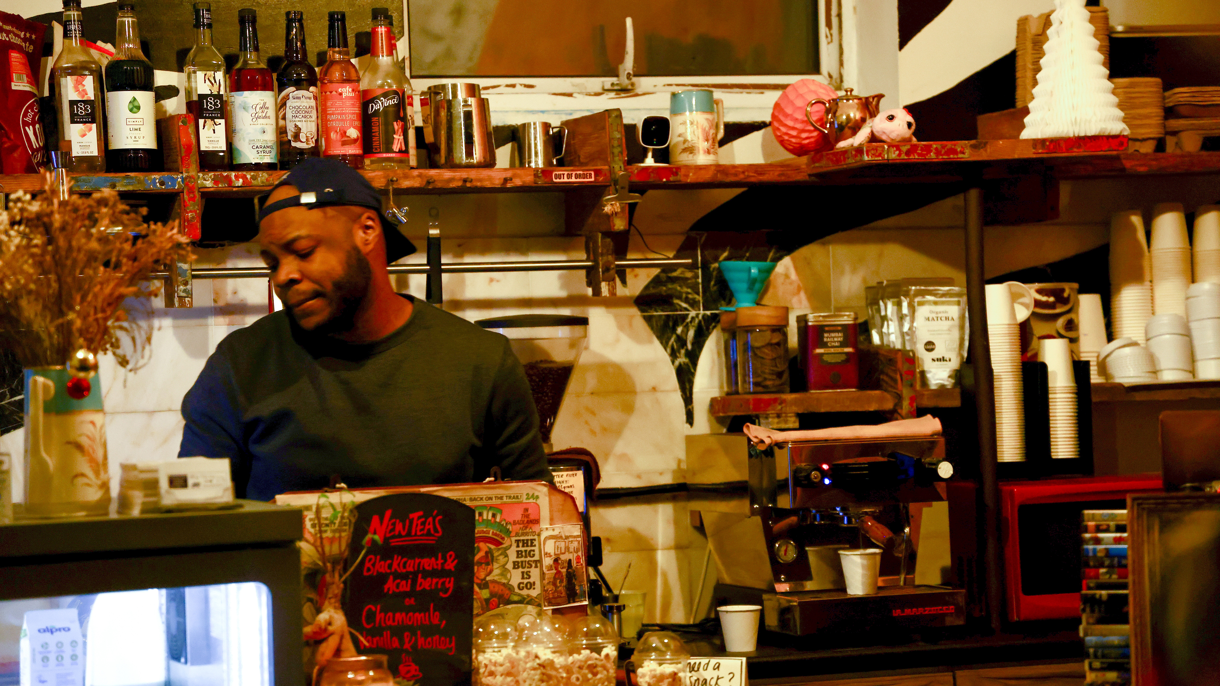 Daniel Imode behind the counter in a cafe.