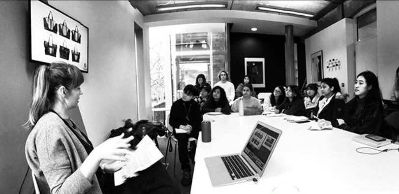 a group of students listening to a speaker