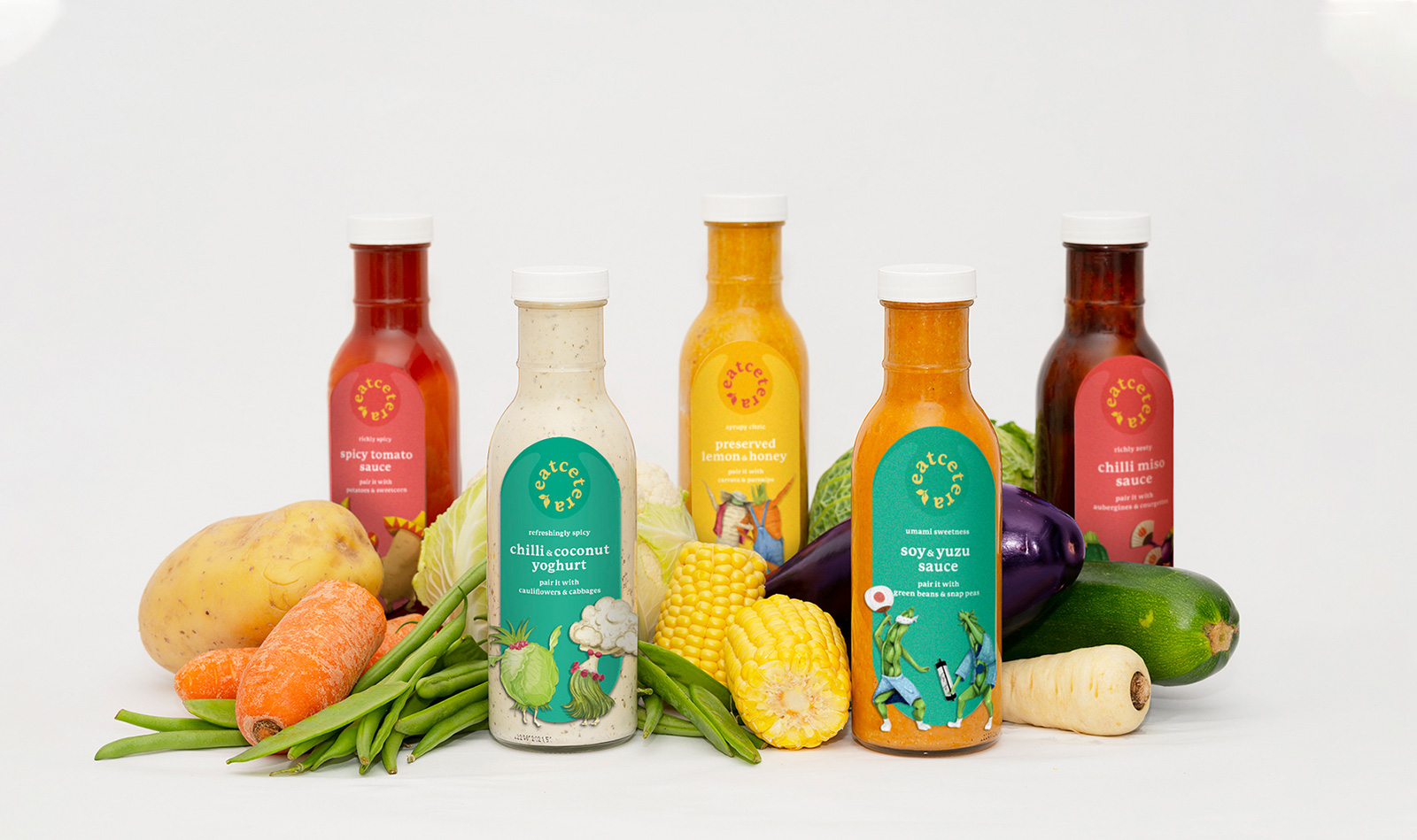 Photograph of sauce bottles surrounded by vegetables.