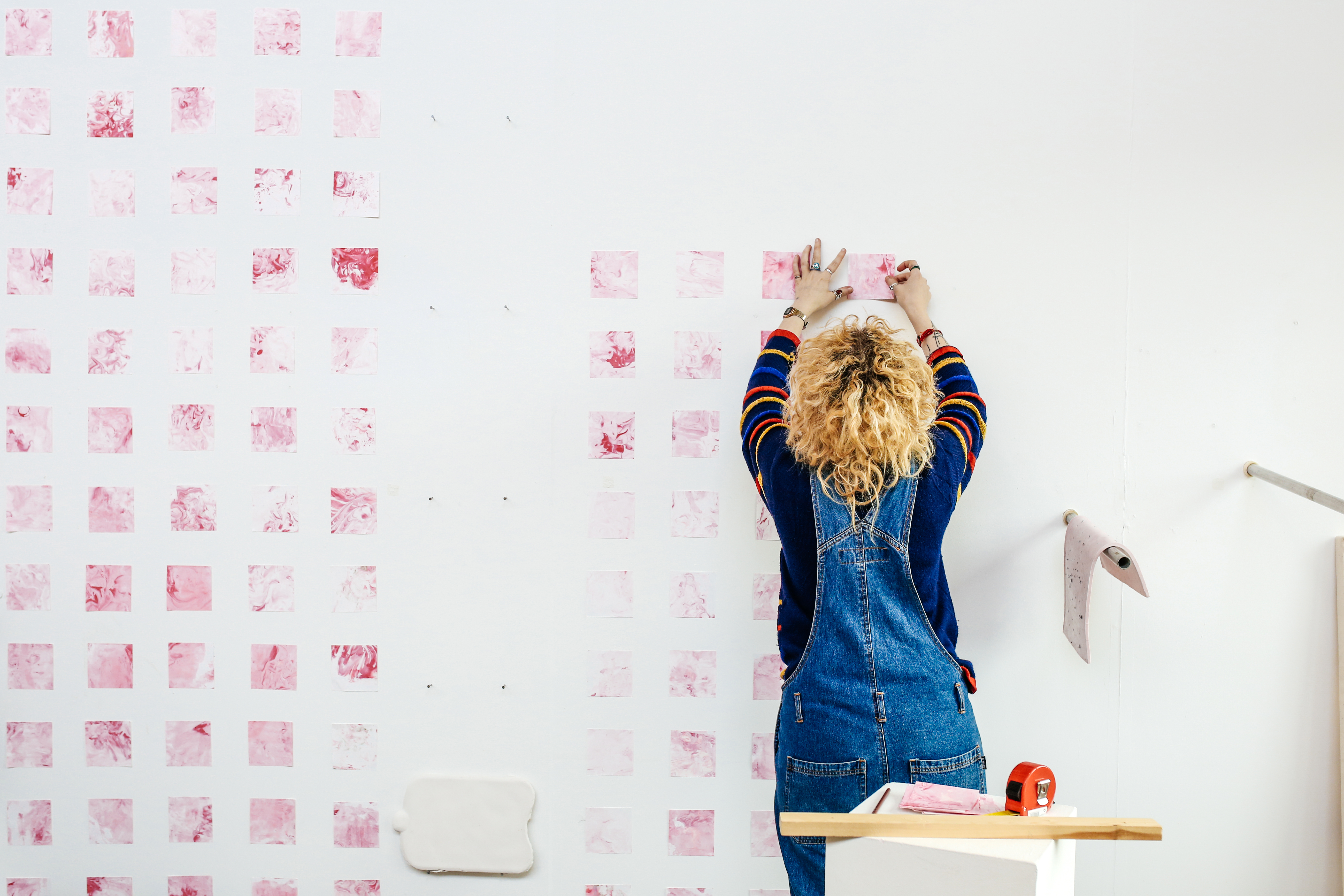 Student creating art on a white wall