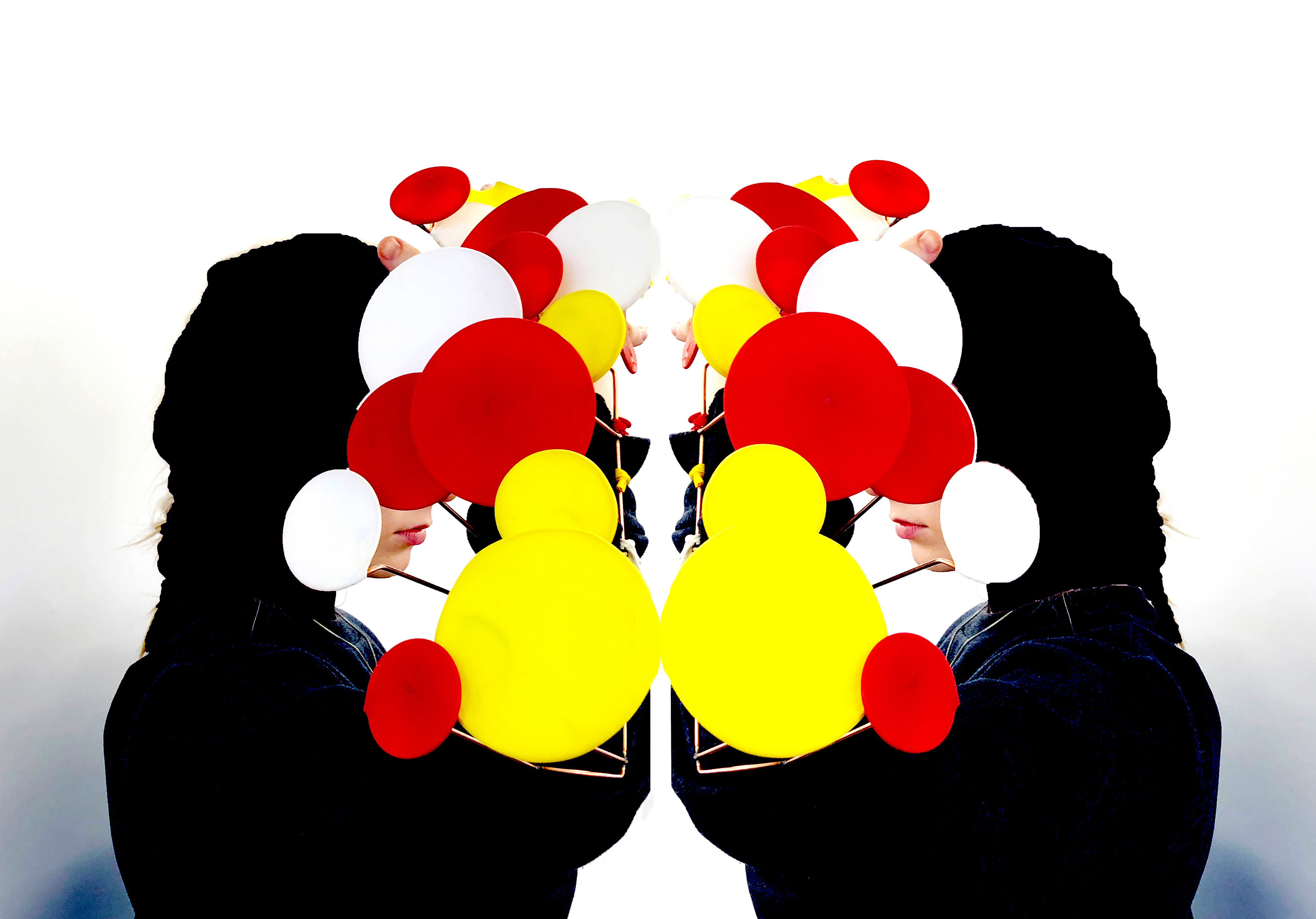 Mirror image of person with red, white and yellow objects in front of face