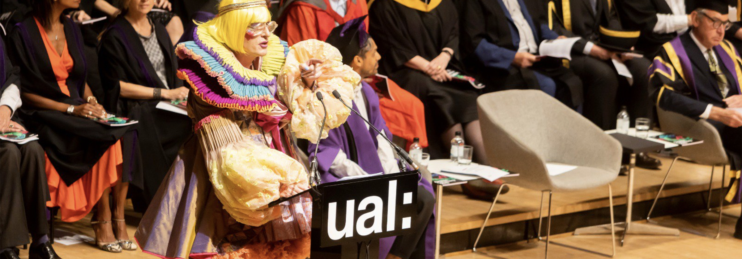 Grayson Perry wearing robes designed by Rachele Terrinoni standing on the stage at graduation