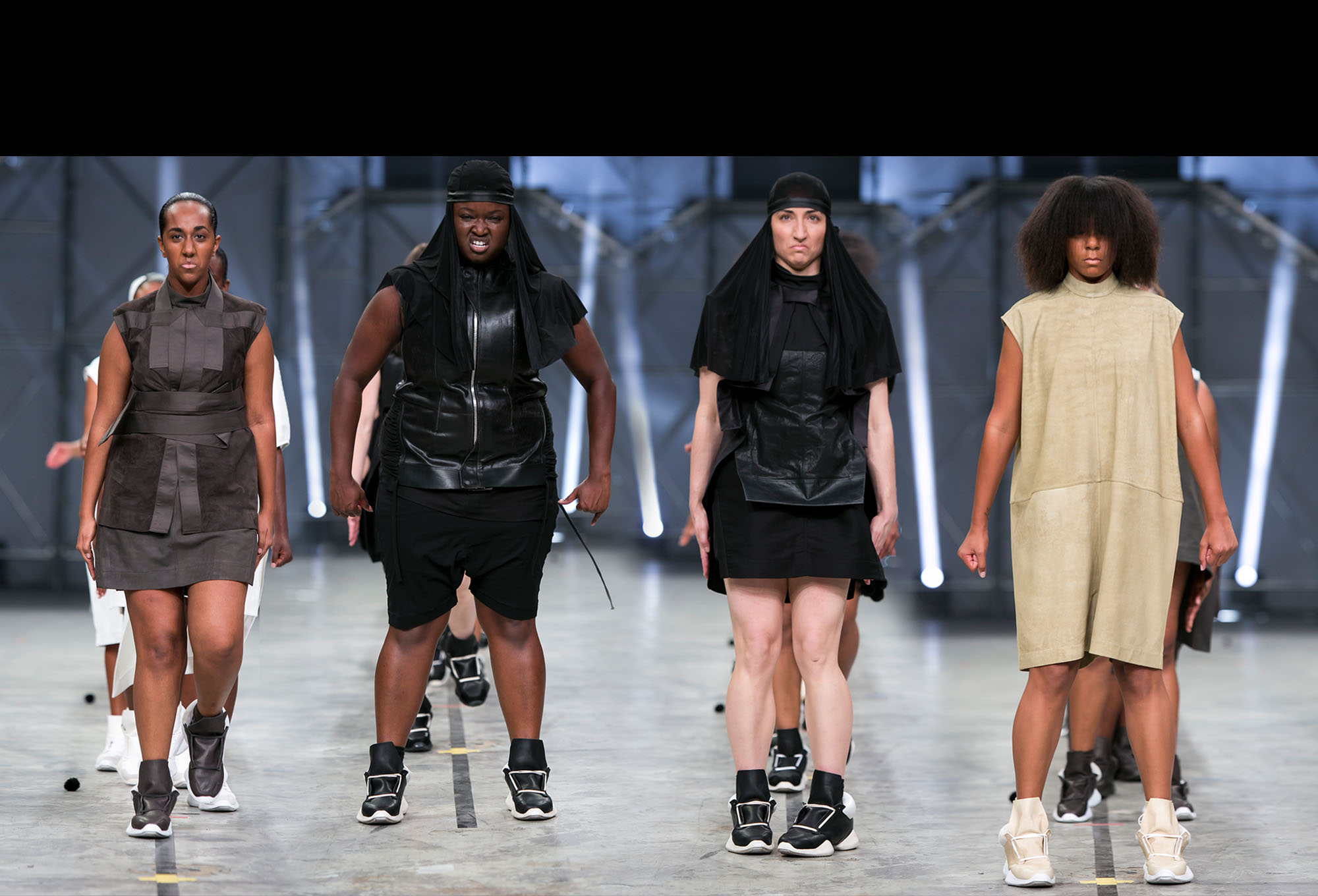 Screen shot from fashion show featuring 4 women commanding the catwalk