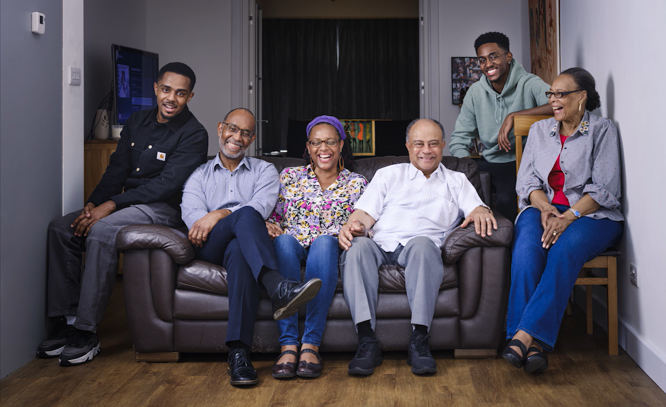 A photos of Jono and his family sat on a sofa smiling