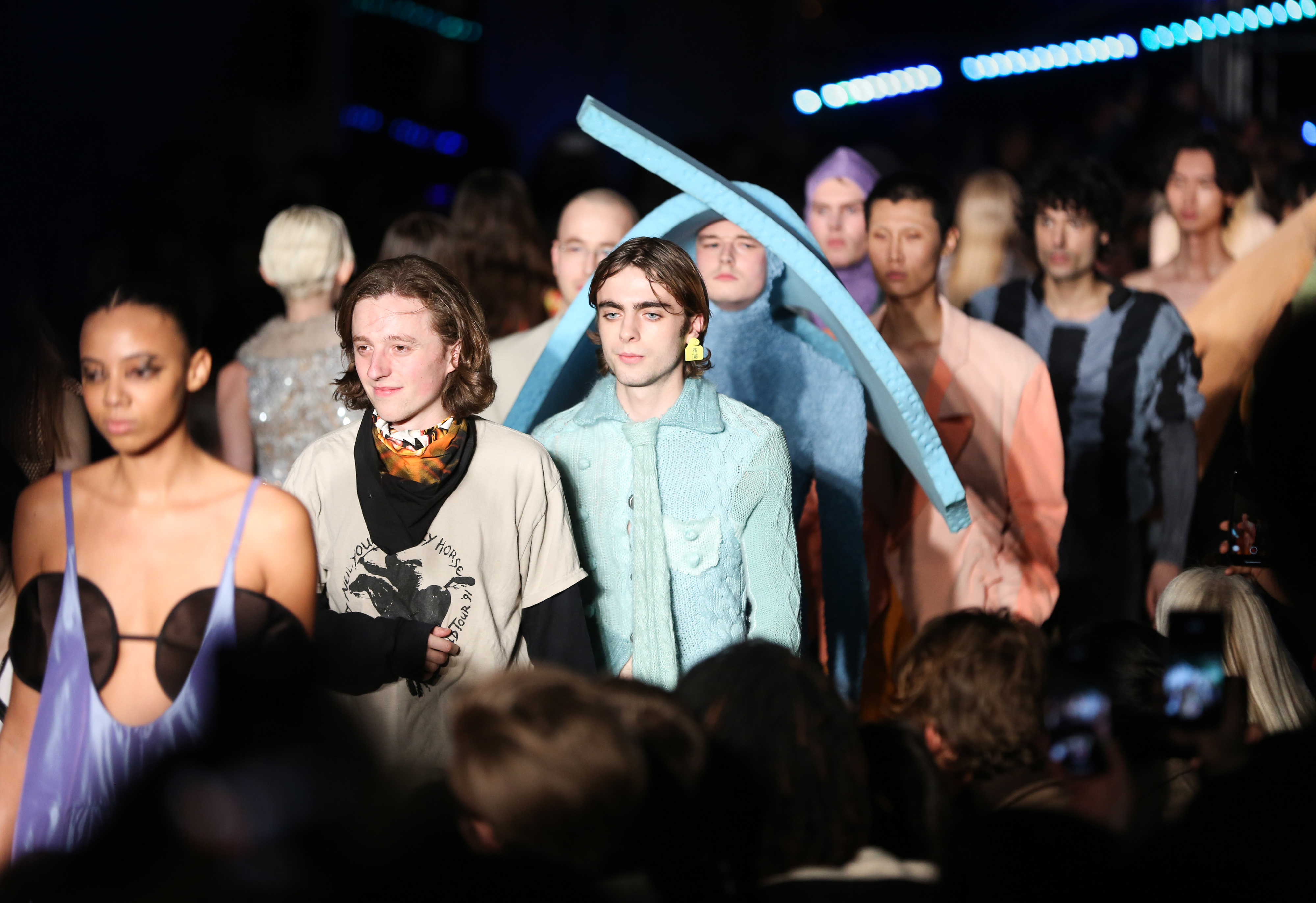 A line of male models walking the catwalk