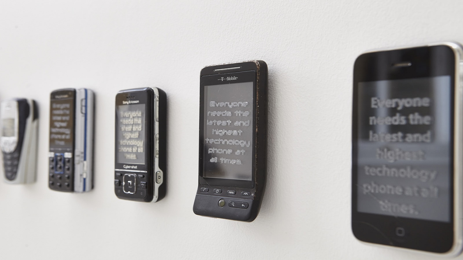 Line of old mobile phones displaying text
