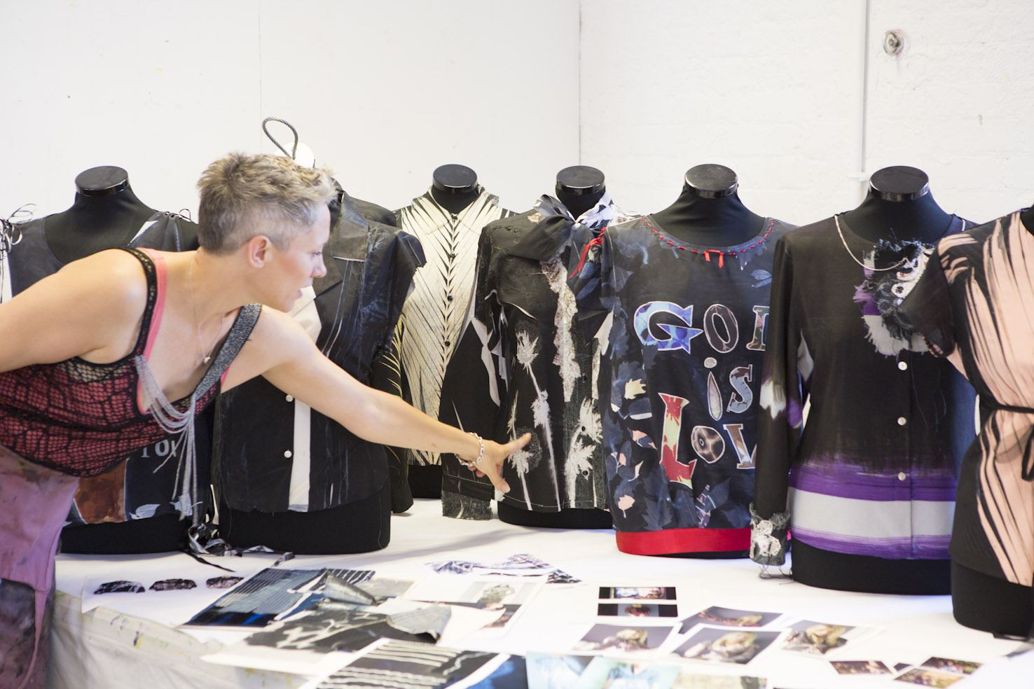 Rebecca Earley in a workshop working with shirts on mannequins and images laid out on a table
