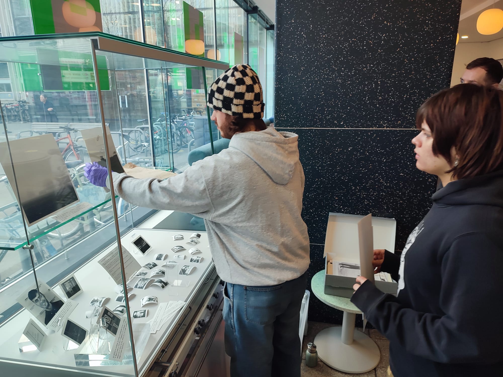 Two students installing items in a display case