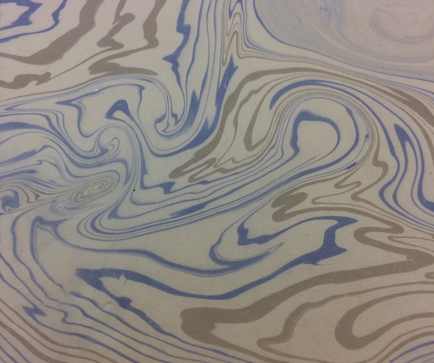 A piece of marbled paper with swirls of blue and grey
