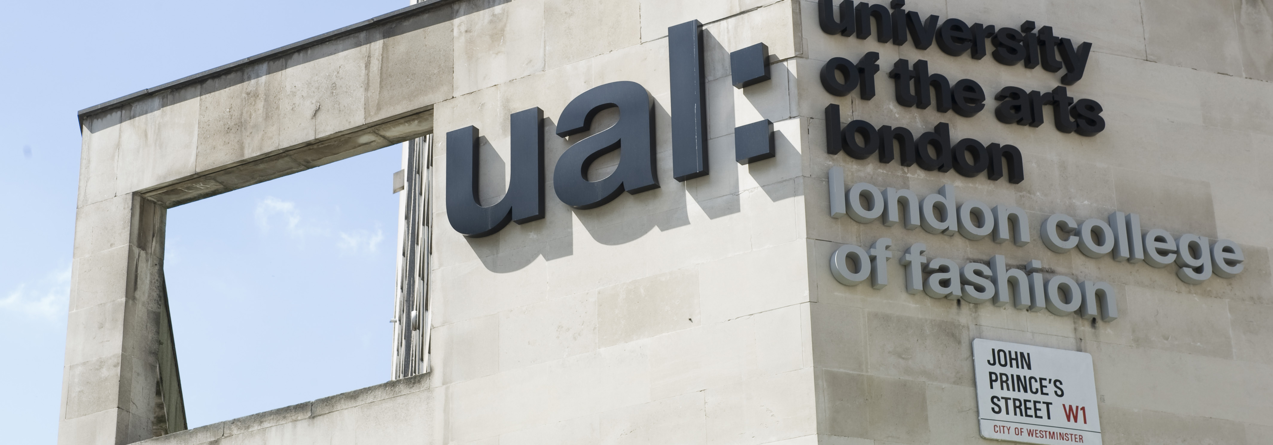 Side of building with big letters logo of UAL and London College of Fashion