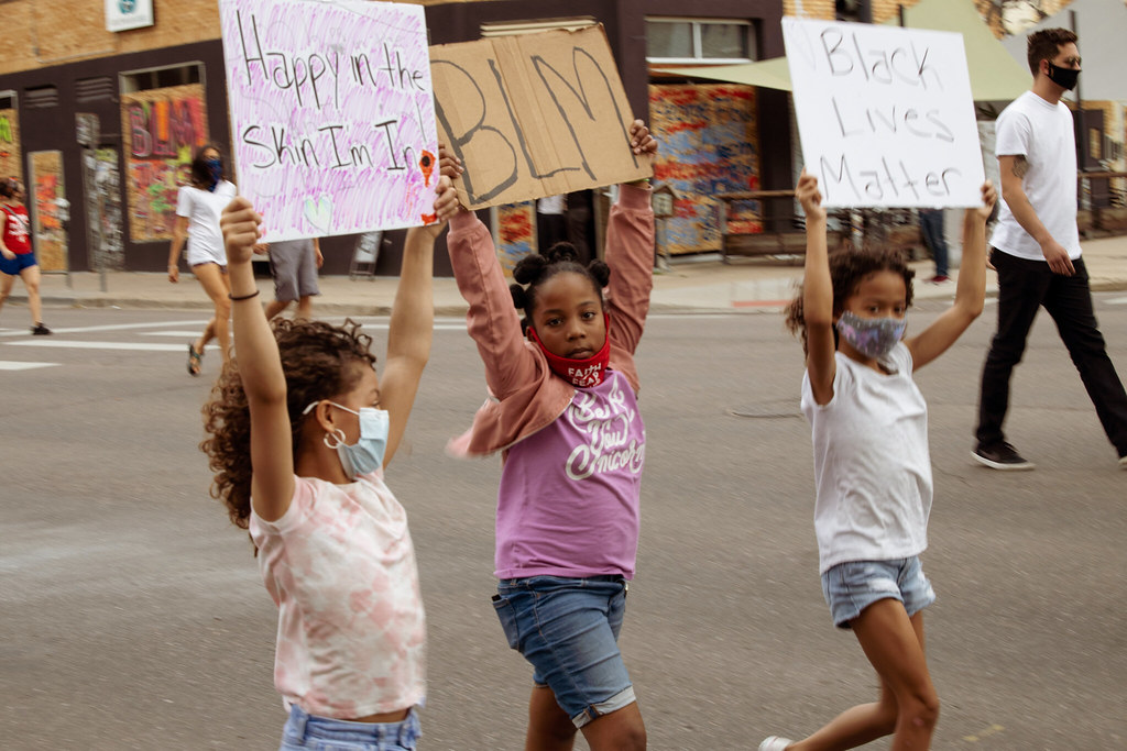 3 young girls marching with placards