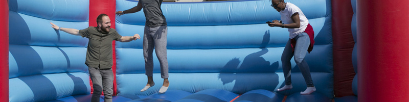 men playing on a bouncy castle