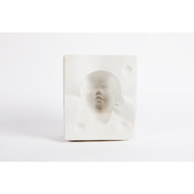 White plaster mould of a dolls face in negative