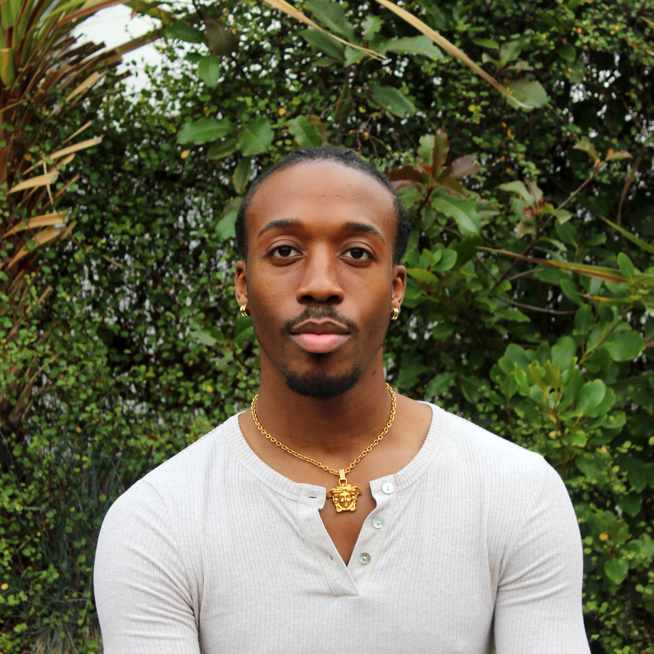 Individual wearing a white top with green background