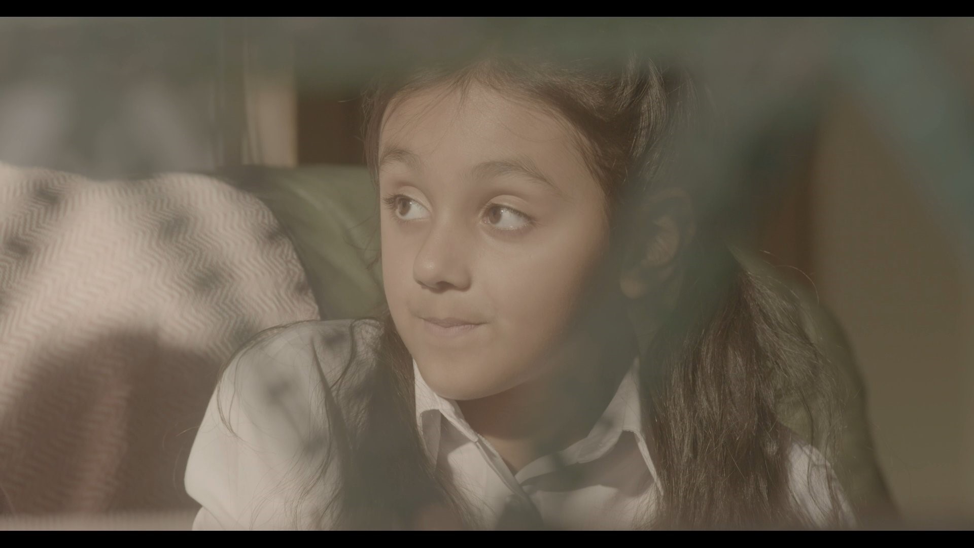 a film screen shot of a little girl looking to the side