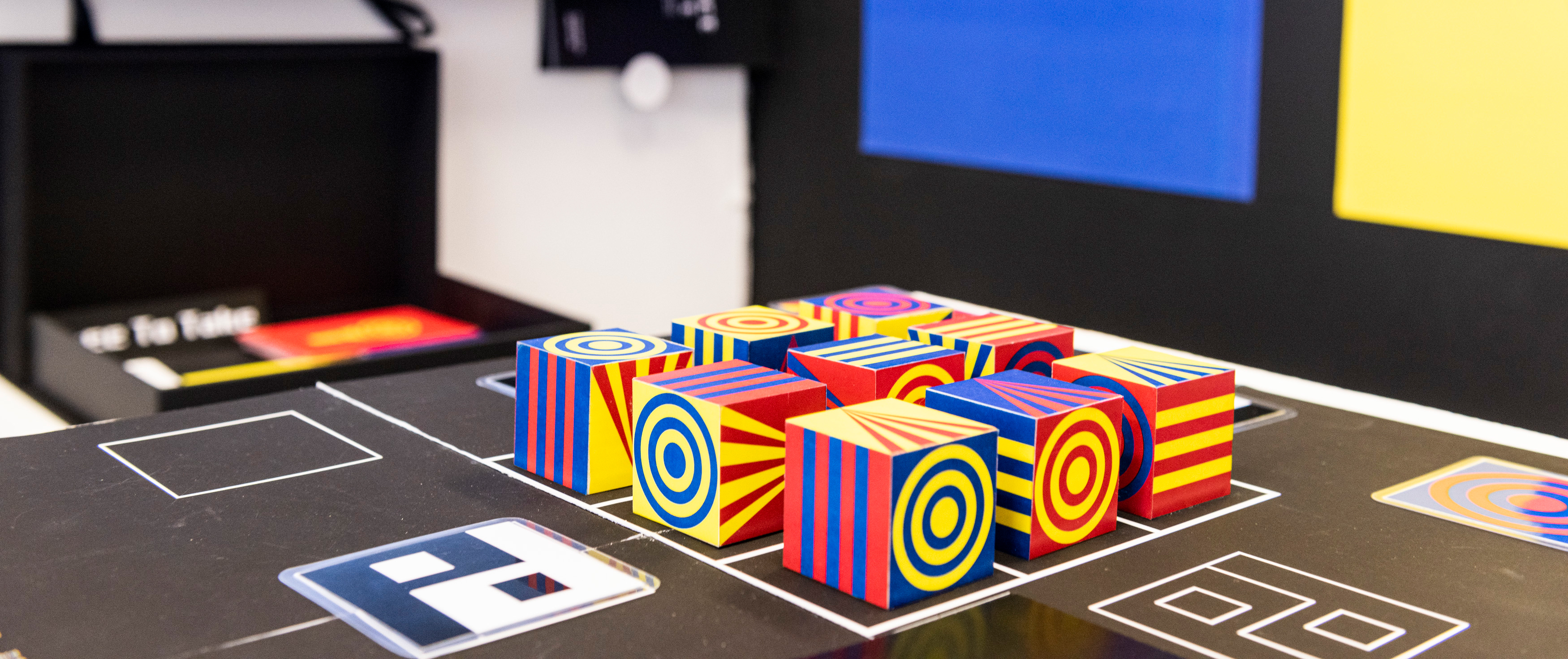 Installation shot of colourful cubes in a grid formation.