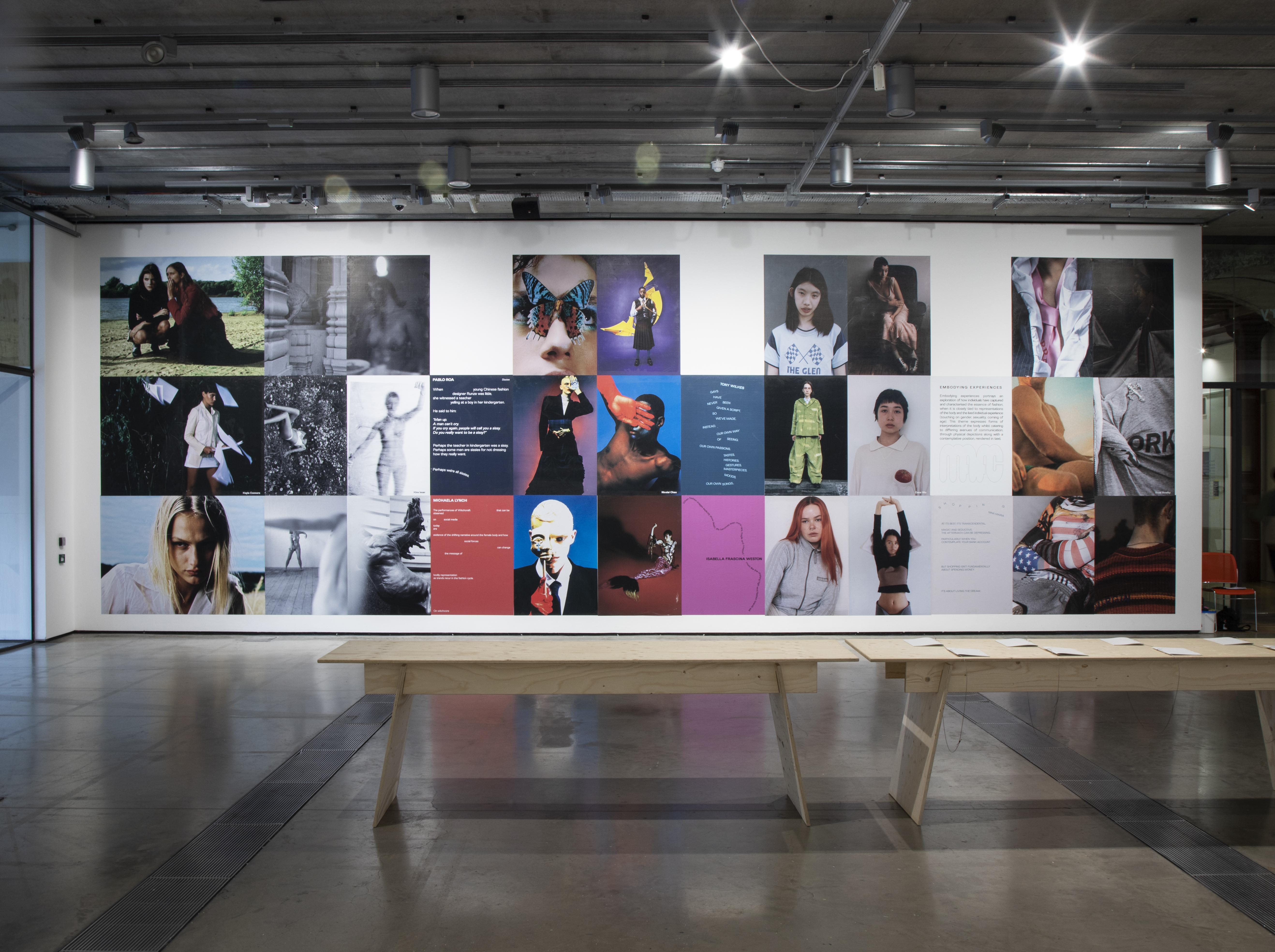 A wide view of an exhibition wall with large colourful fashion editorial images and portraits.