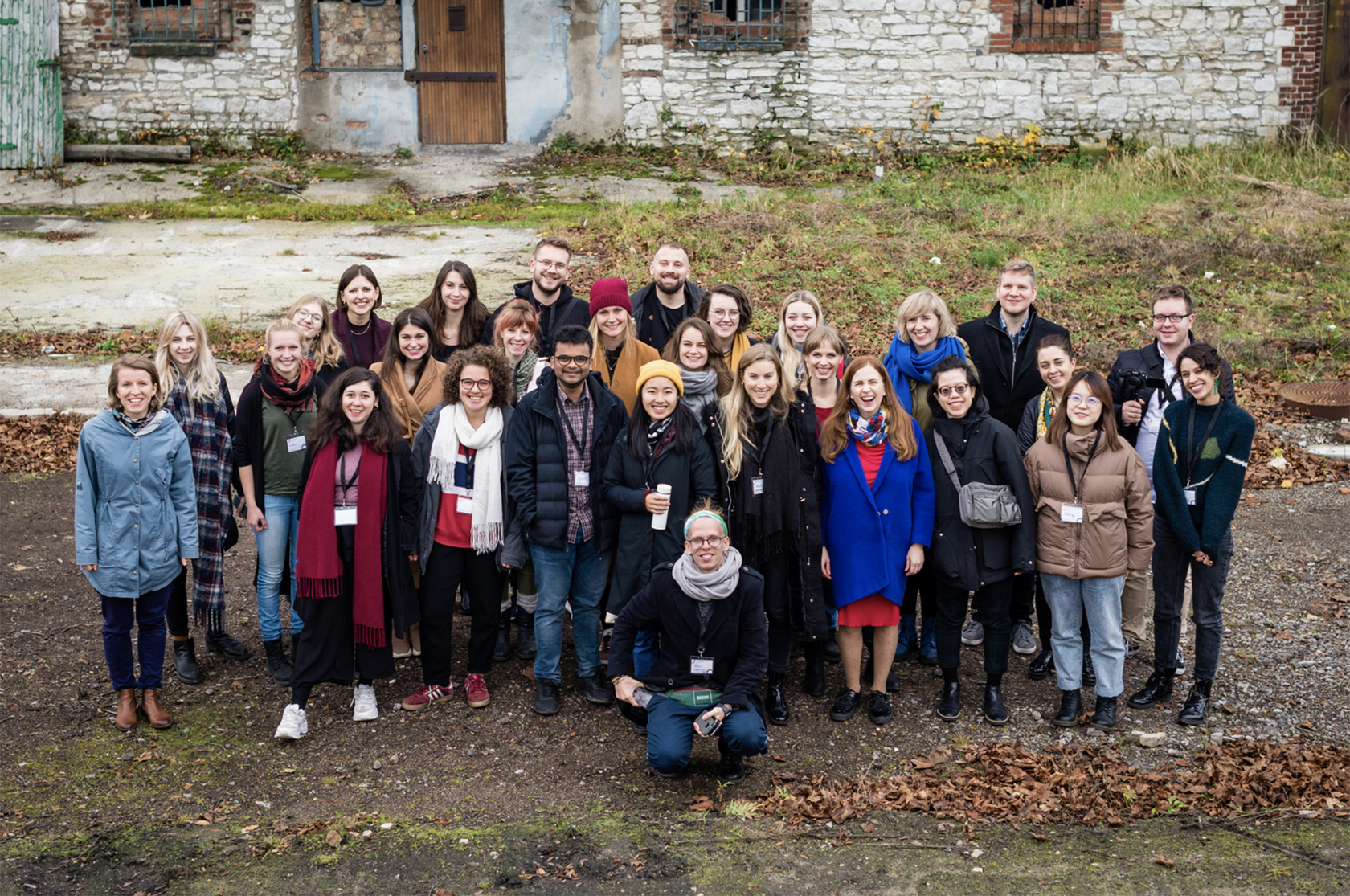 Group photo of students and academics in front of an old building