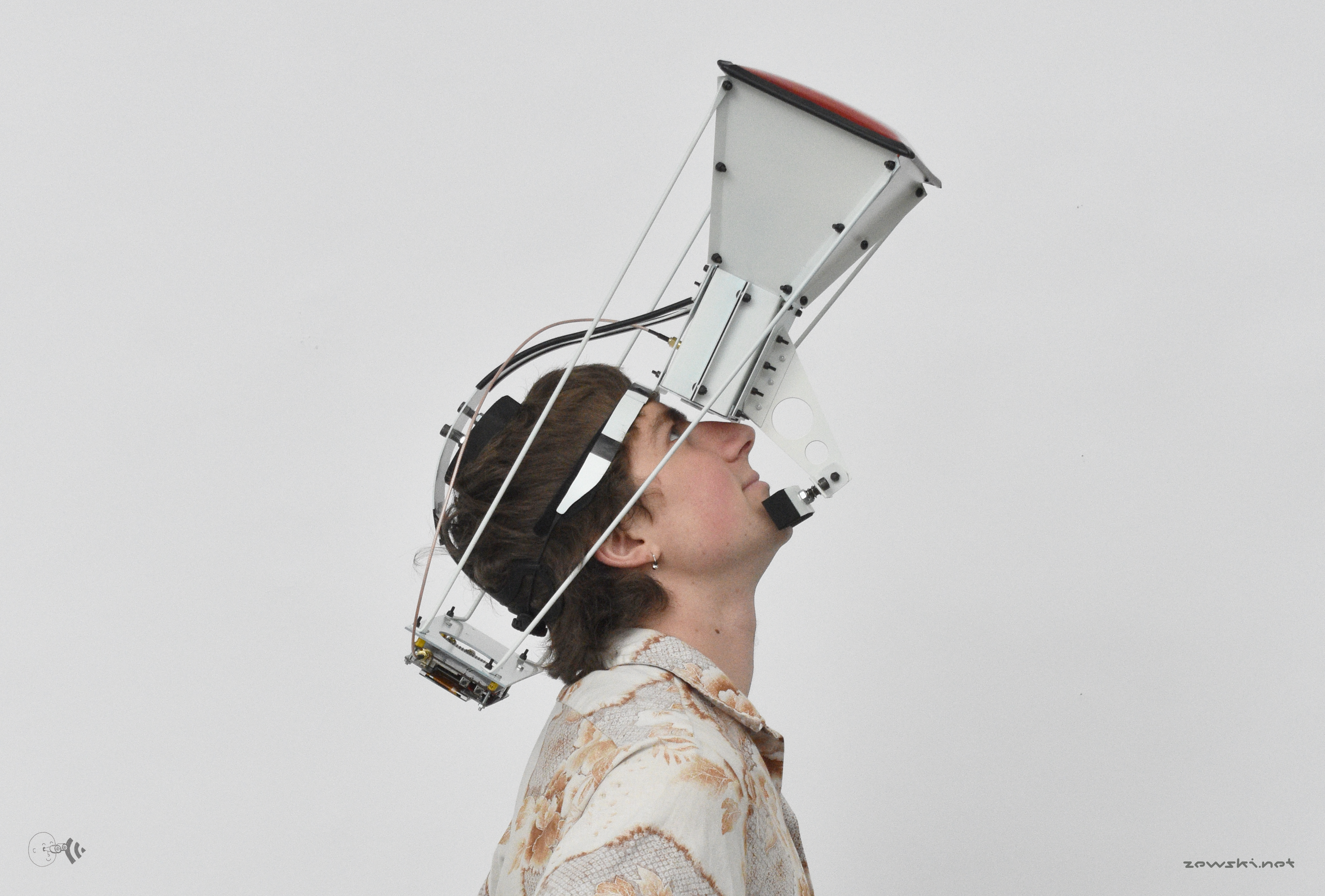 Young adult white male looks upwards into a metal construction strapped to his head