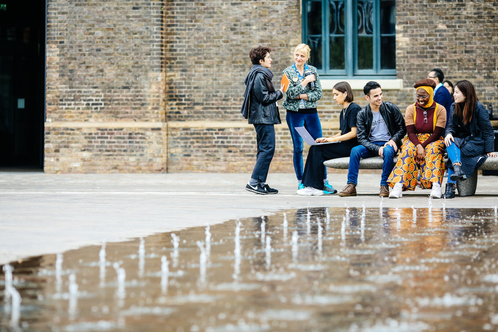 Students talking outside fountain at Central Saint Martins, UAL 