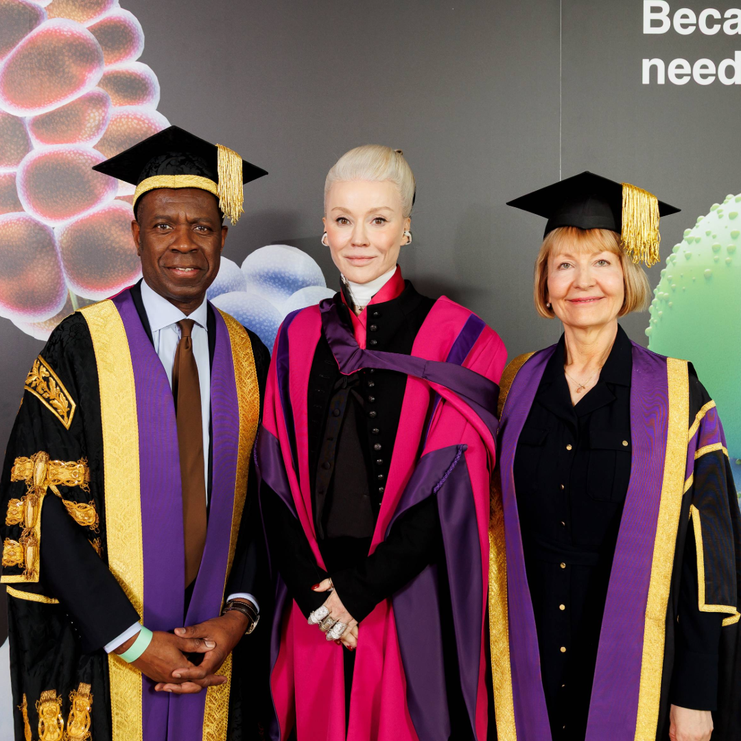 An image of three people in ceremonial graduation gowns