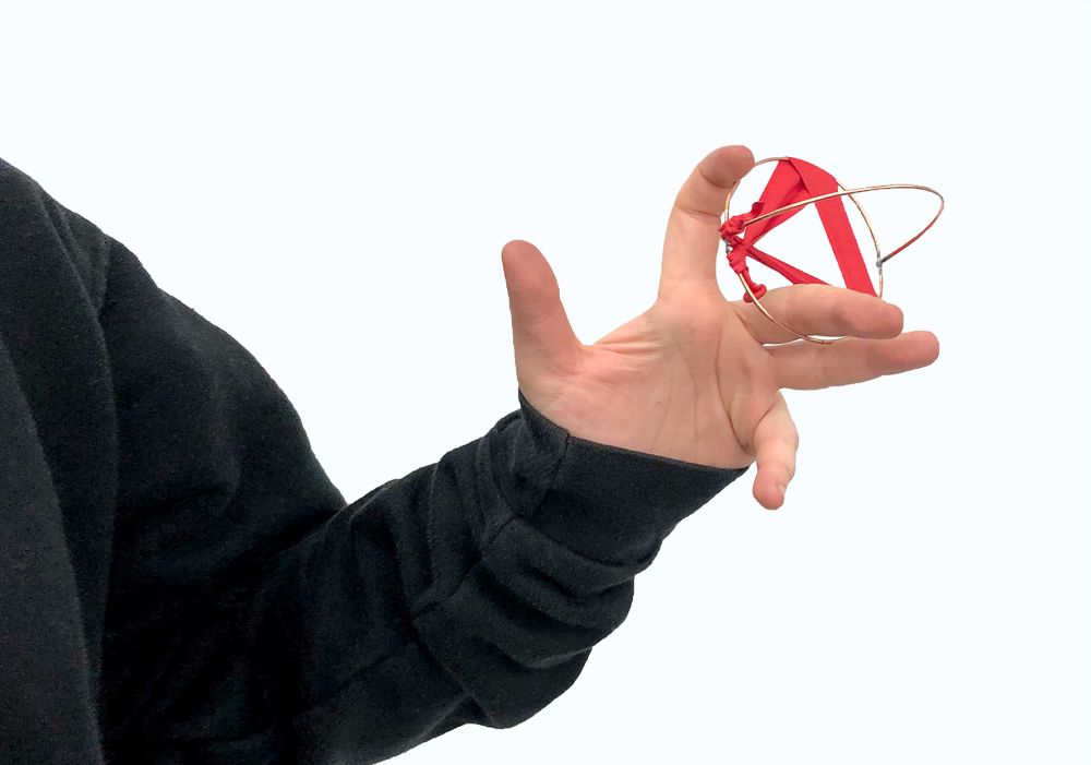 Metal and rubber object entwined on fingers