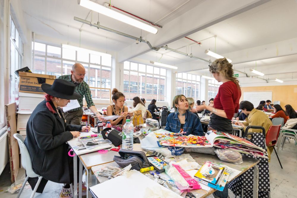Students working at a desk inside Central Saint Martins' Archway campus