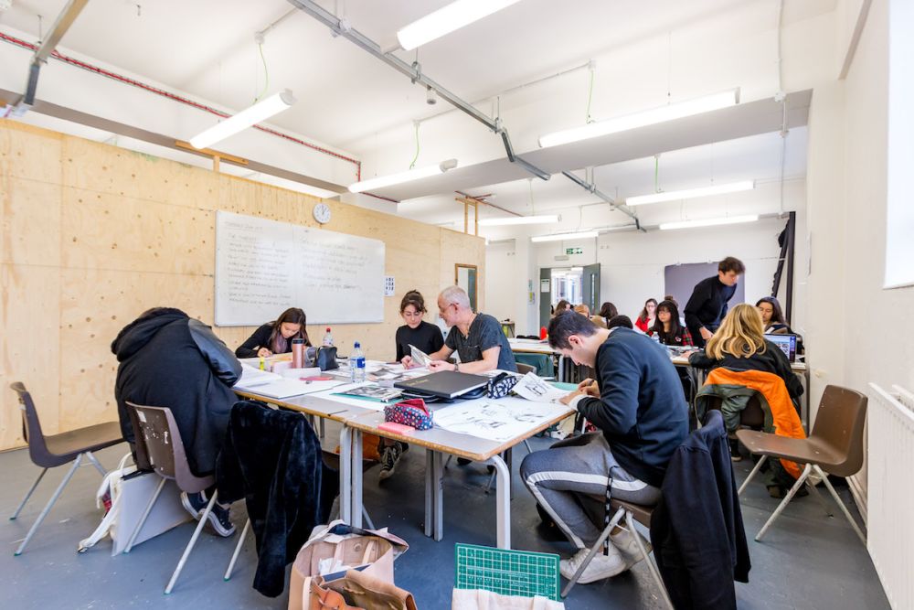 Students working at a desk inside Central Saint Martins' Archway campus