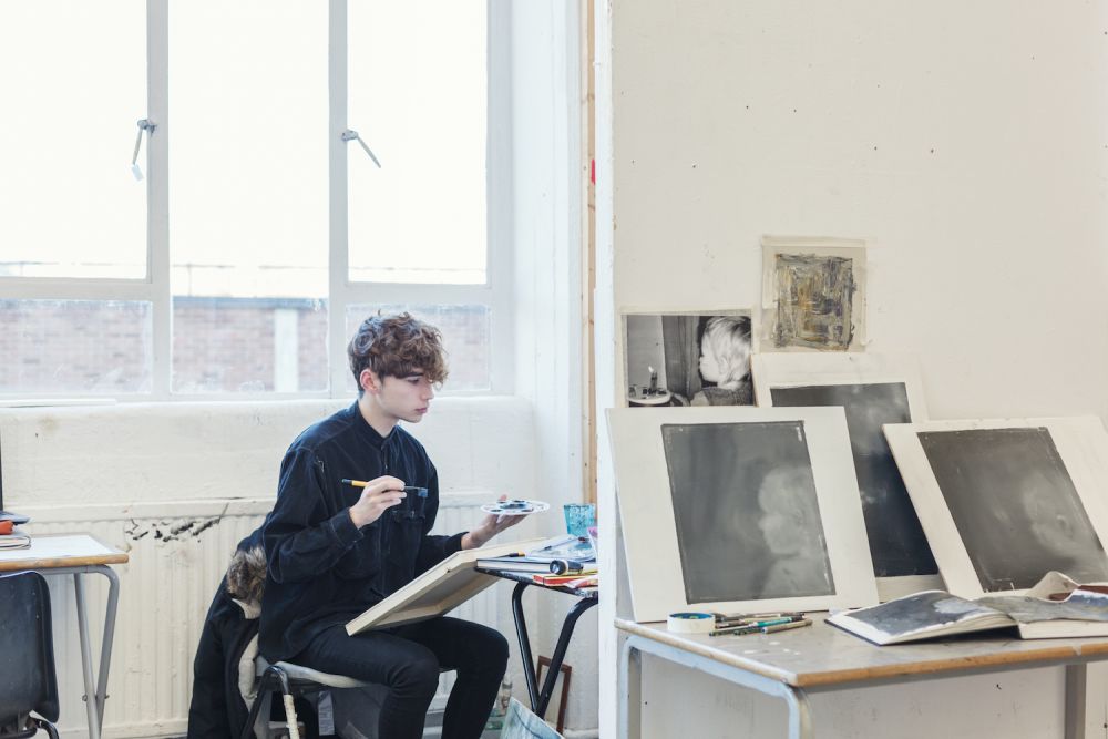 A student sat down painting