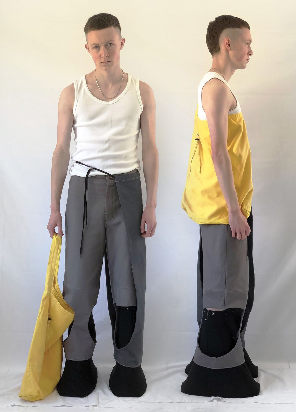 Man wearing wide dark trousers and yellow top