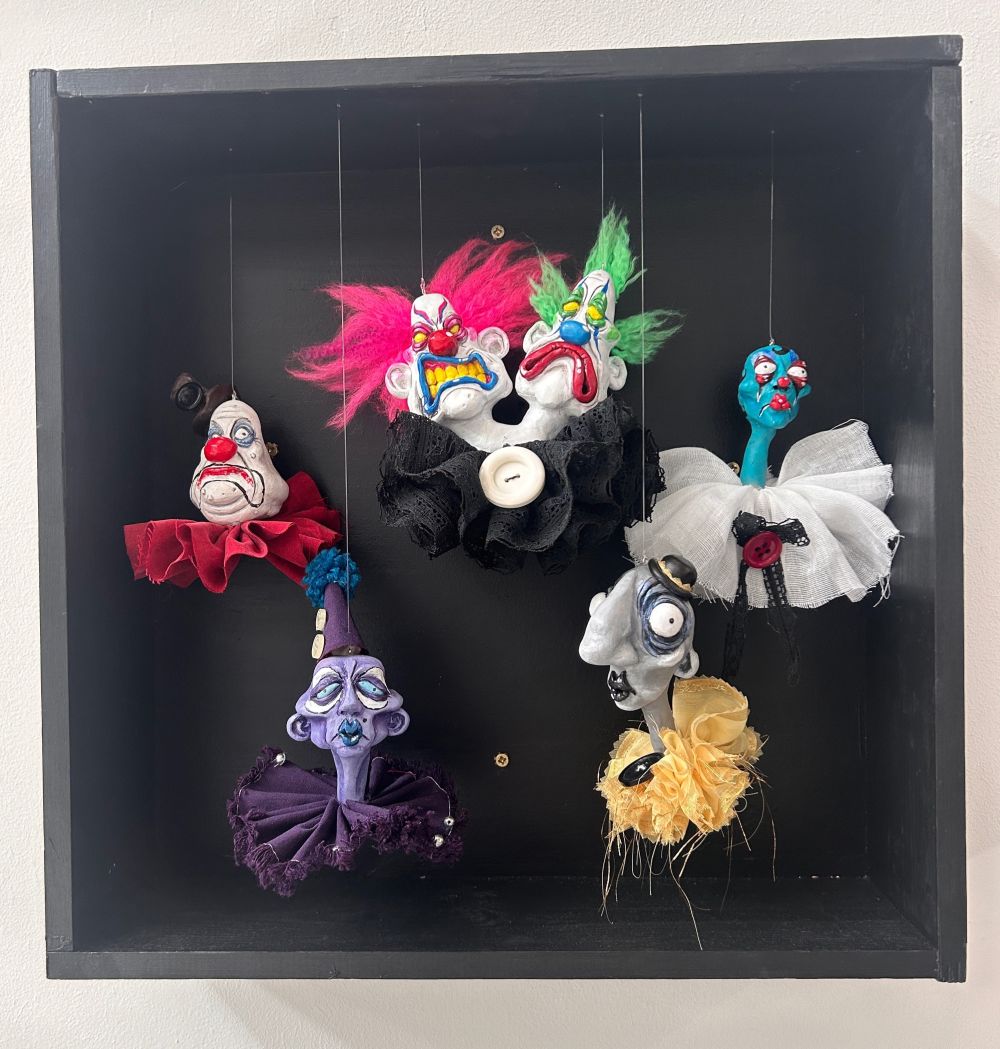 wooden box with hanging series of 3D sculpture heads