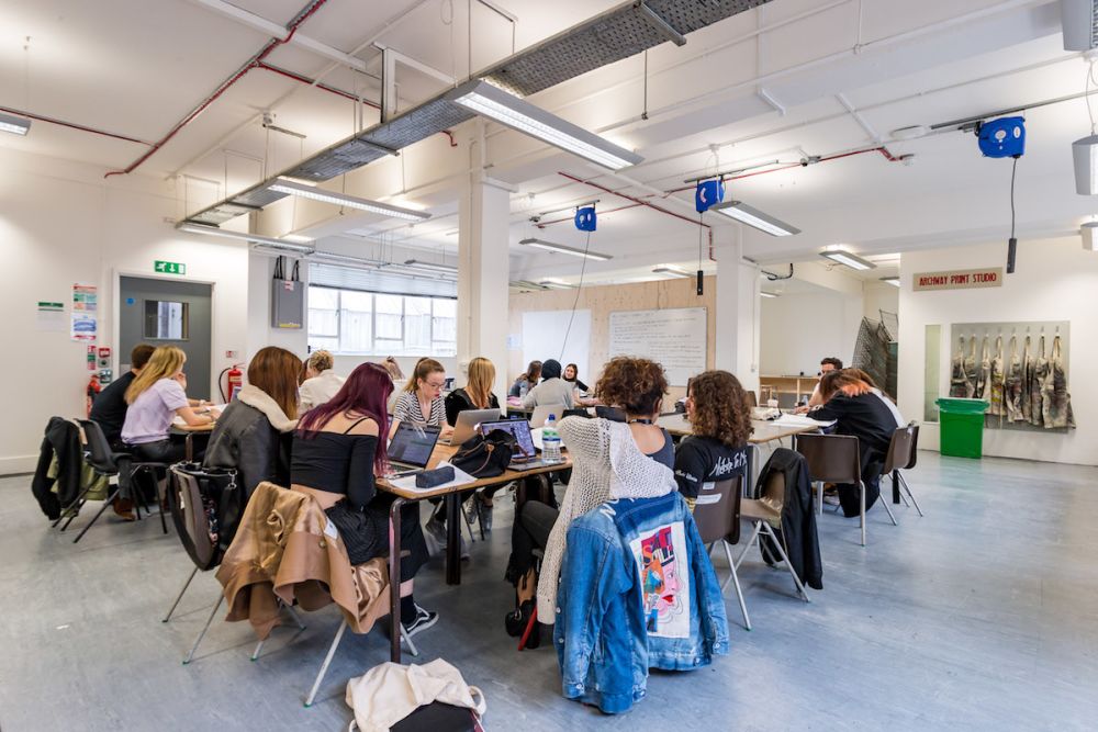 Students working at a desk inside Central Saint Martins' Archway campus