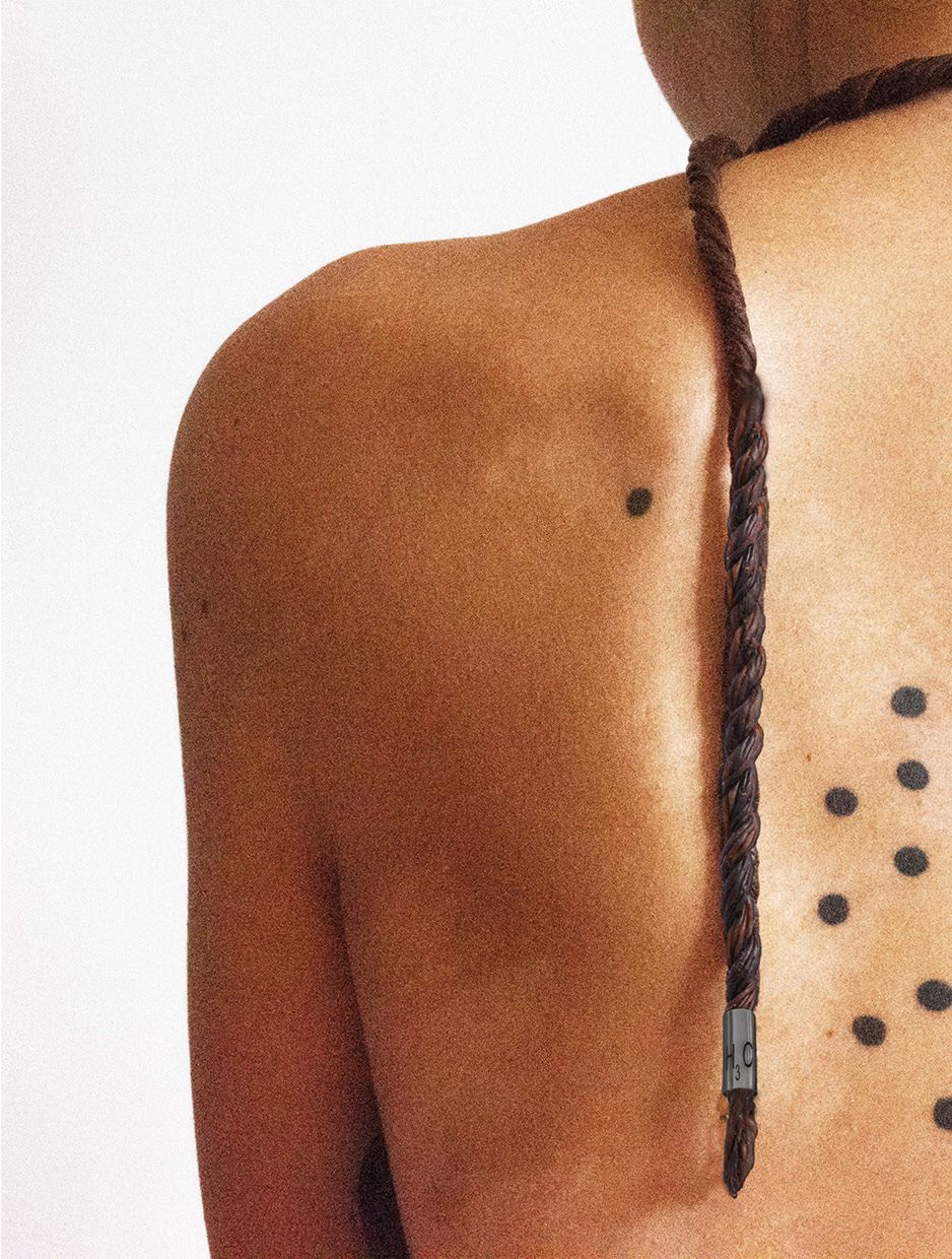 Person's back with rope-style materials hanging down