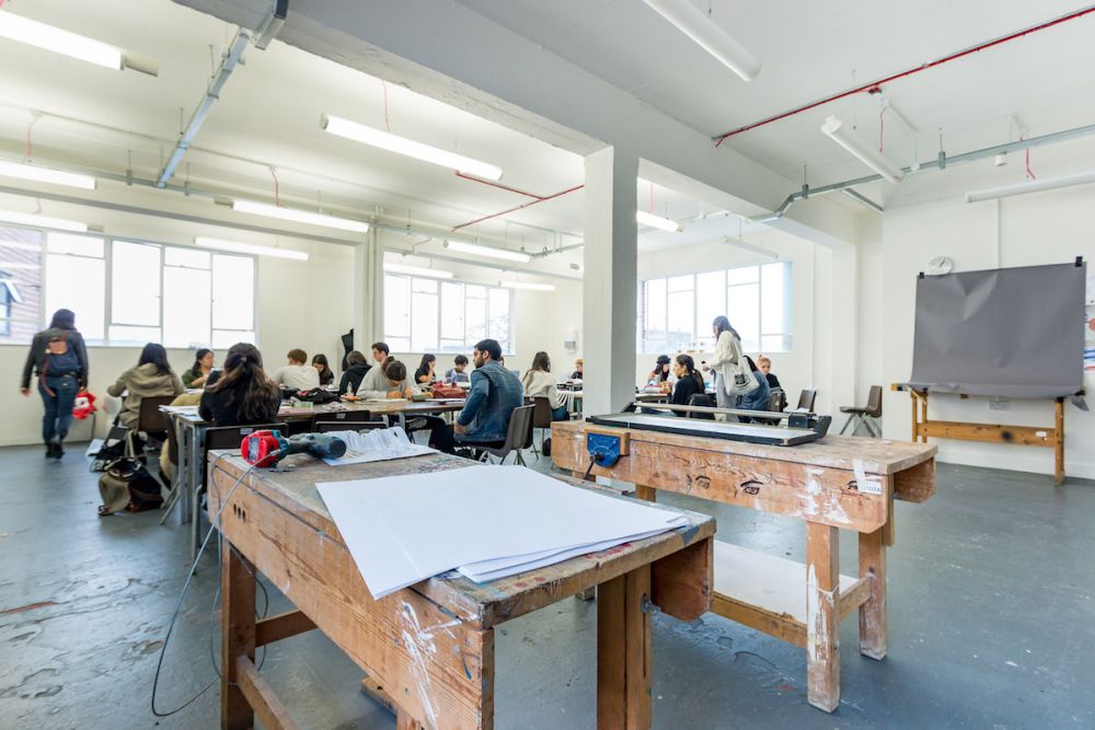 Students working at a desk inside Central Saint Martins' Archway campus