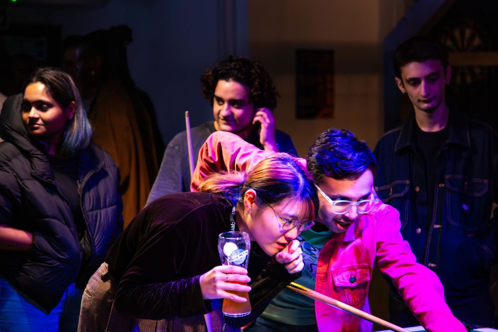 Students playing pool together with him light upon them