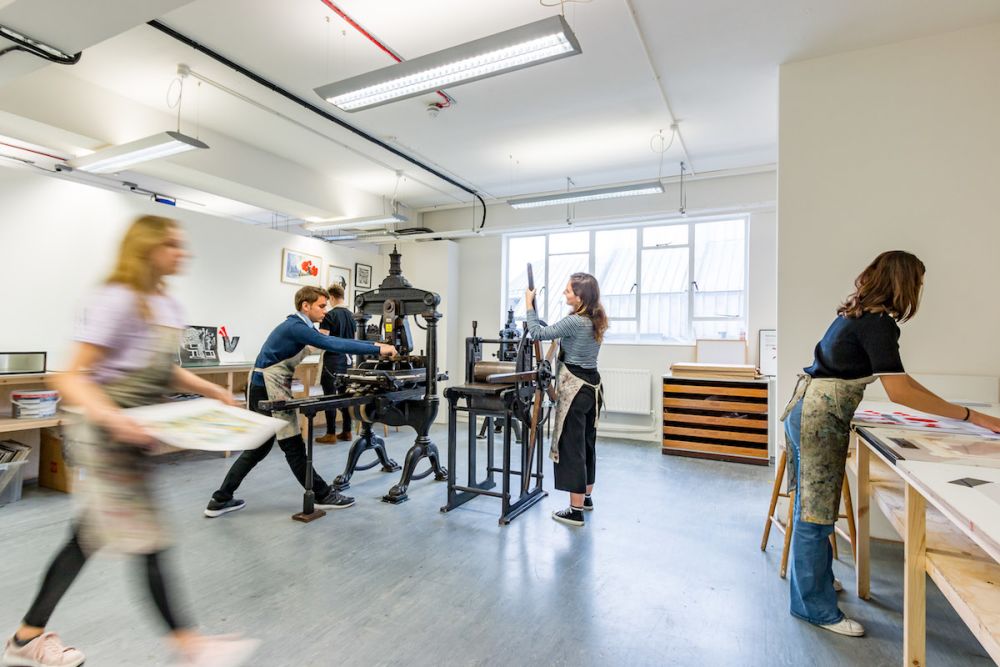 Students using a printing press  inside Central Saint Martins' Archway campus