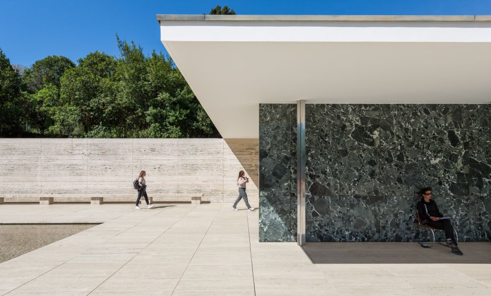 person walking into building with blue skies
