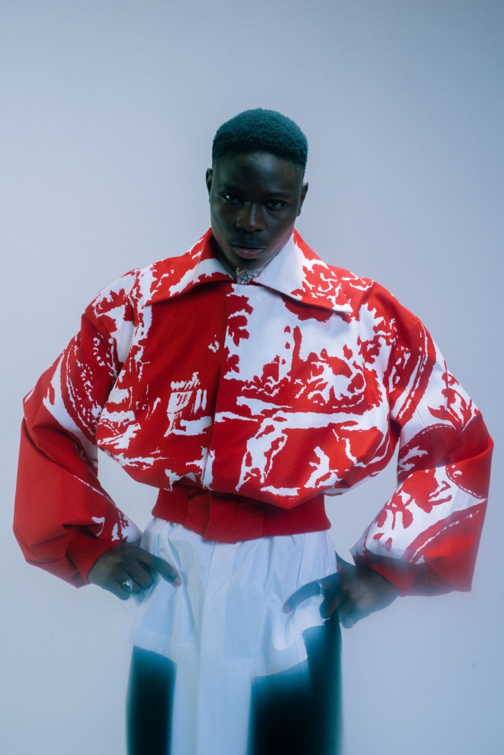 Male model in cropped, red and white coat with wide collar.