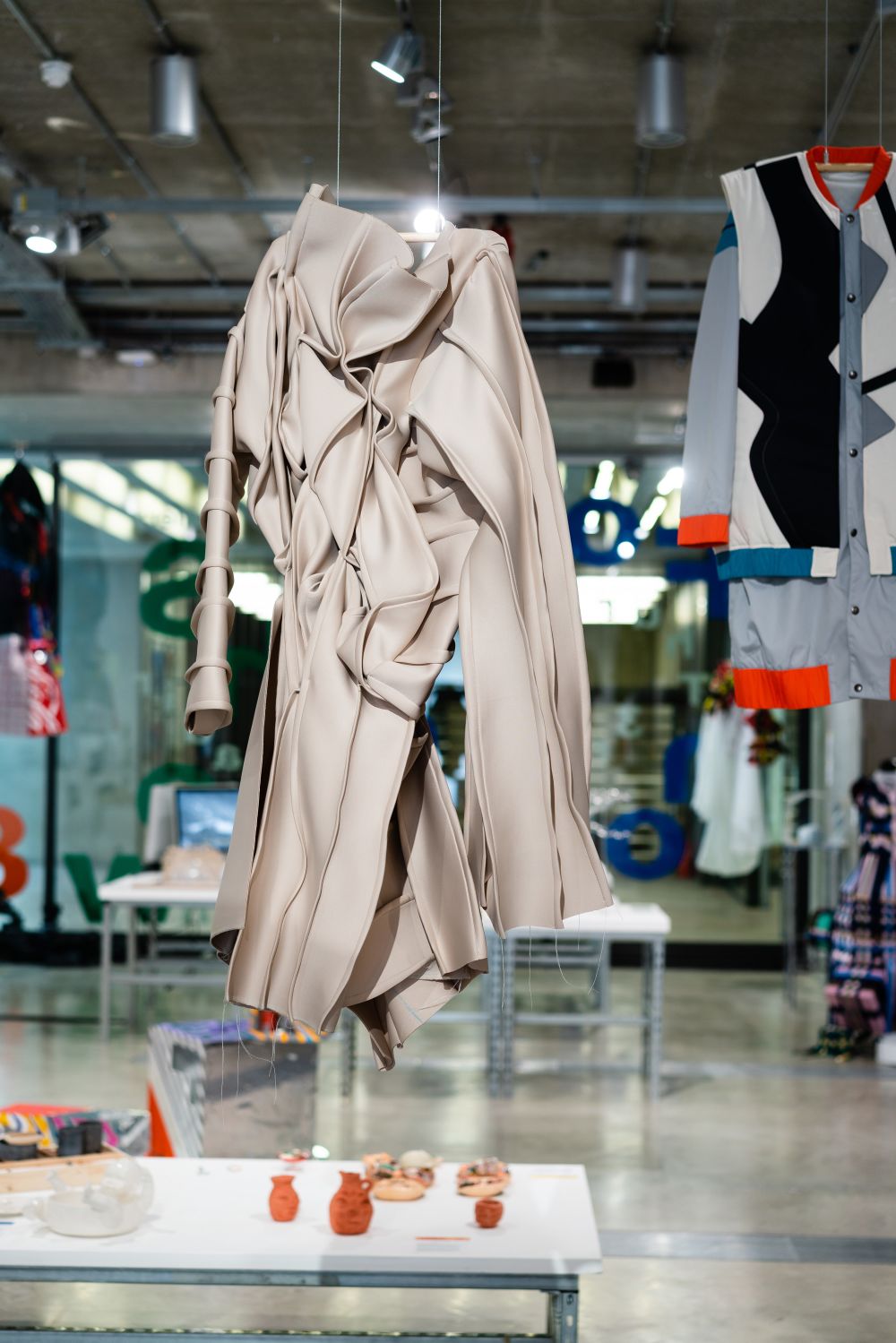 A silver garment on display in a gallery