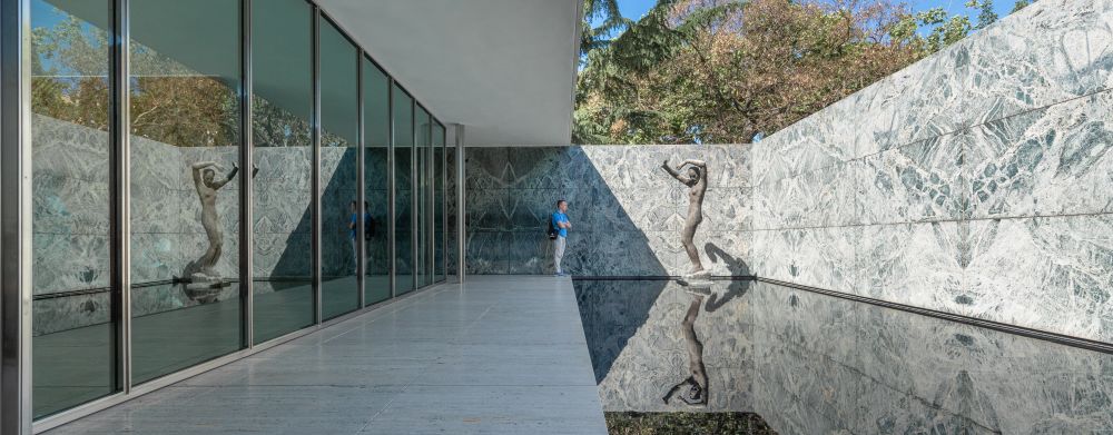 building view with sculpture in pond