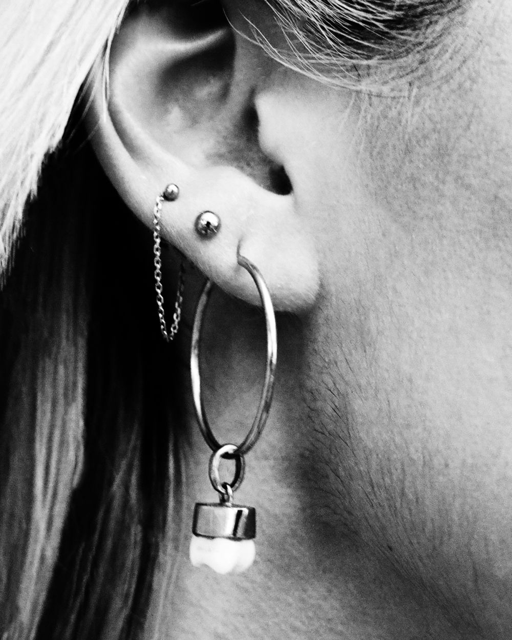 Close up shot of a woman's earring shaped like a tooth