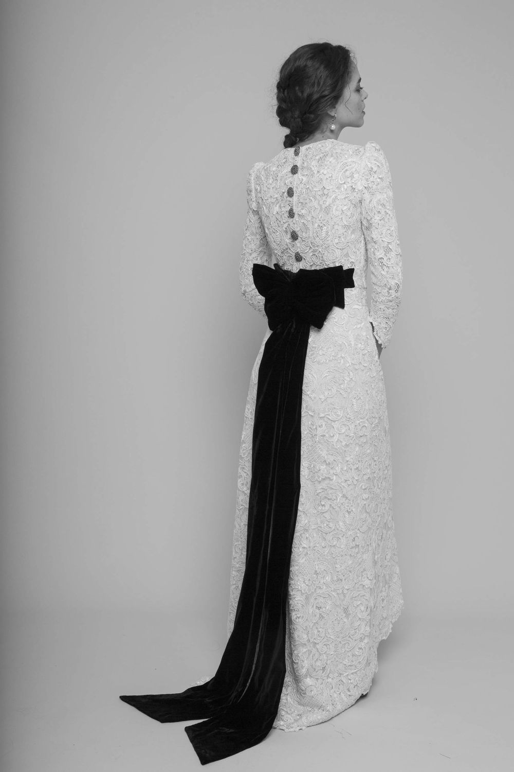 model wearing white wedding dress with black bow in the back