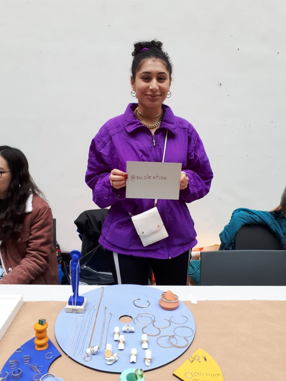 student at holiday market holdin gup a card with instagram handle written onto it