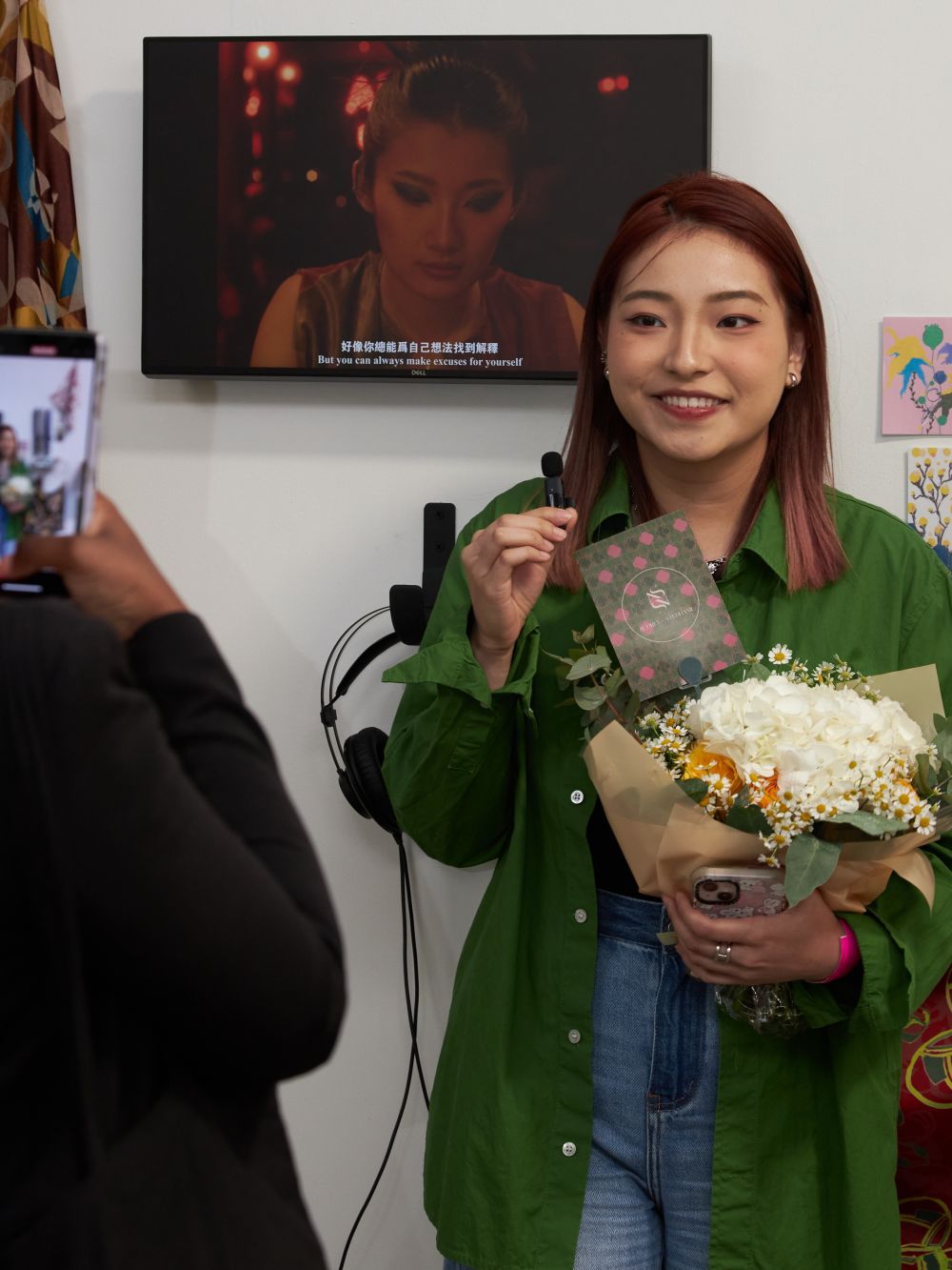 Student with flowers in front of screen